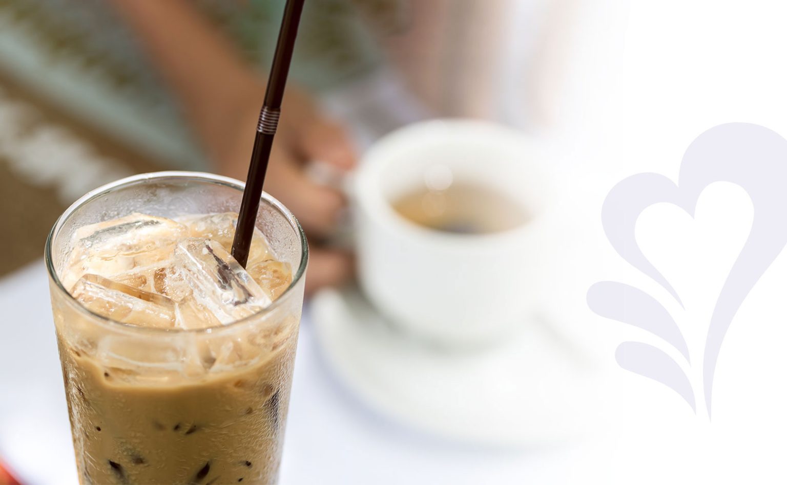 Image of a full glass of iced coffee with a black straw