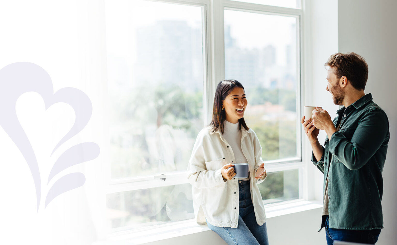 Coworkers chatting with coffee mugs in their hands