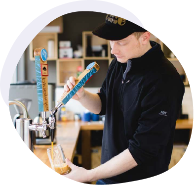 Employee pouring cold brew coffee from a tap handle in an office setting