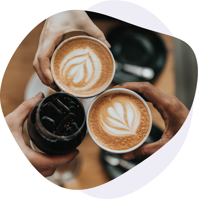 Three coffee cups in a circle - one cold brew and two lattes with latte art