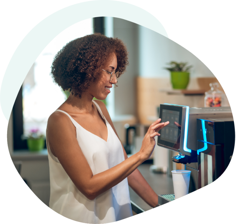 Employee operating a bean to cup coffee machine in an office