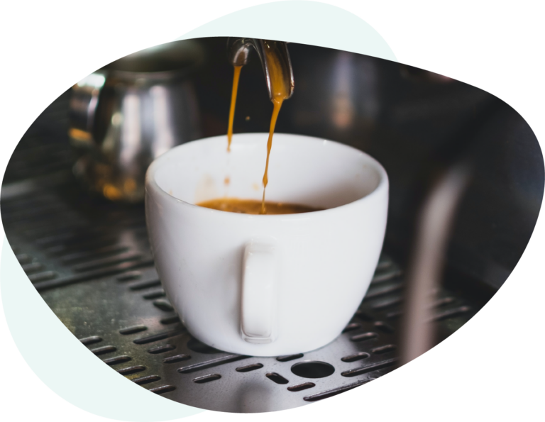 Espresso dripped into a white cup during the brew process