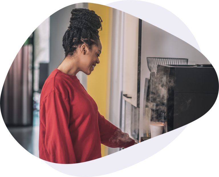 Woman brewing coffee from a single cup coffee machine in an office setting