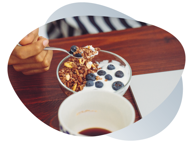 Yogurt parfait on a desk w/ a cup of coffee or tea